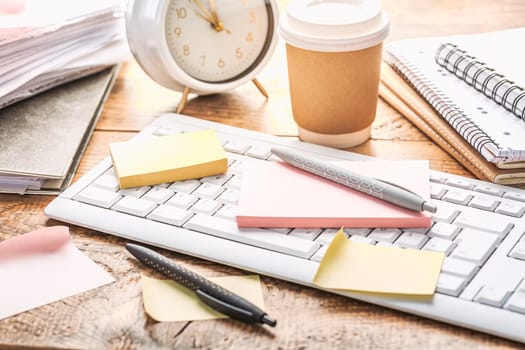 Time management concept. Composition with alarm clock on wooden table with laptop computer, stationary and post-it notes