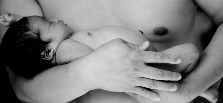 a newborn baby in fathers arm