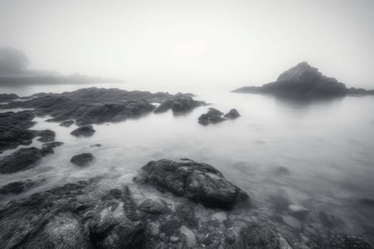 Sometimes, the ocean can seem like it exists in a dream world of its own. This scene captures that dreamy quality perfectly with its soft-focus and misty ambiance. A small, rocky island sits in the distance, adding a touch of mystery and intrigue. Rendered in stunning high resolution and monochrome tones, this is a scene that is both calming and captivating. (generative AI)