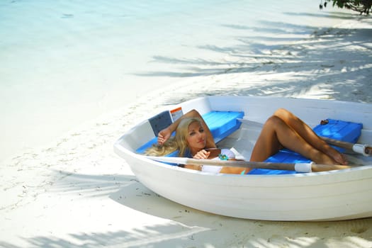 woman in boat under palm on sea background