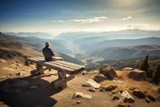 At the top of a mountain, a person sits on a bench, looking out at the breathtaking view below. The scene is majestic and scenic, with the vastness of nature stretching out all around them. This setting can evoke feelings of reflection, contemplation, and the awe-inspiring beauty of the natural world. (generative AI)