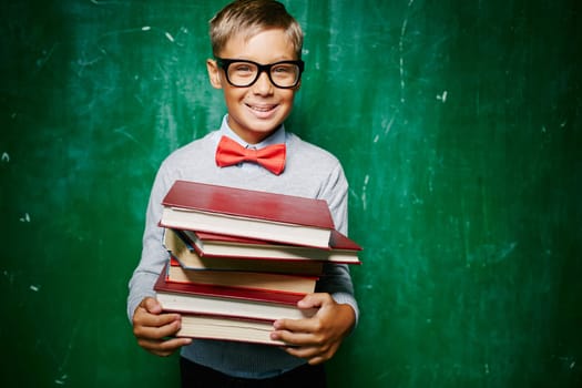 Handsome learner with stack of books looking at camera