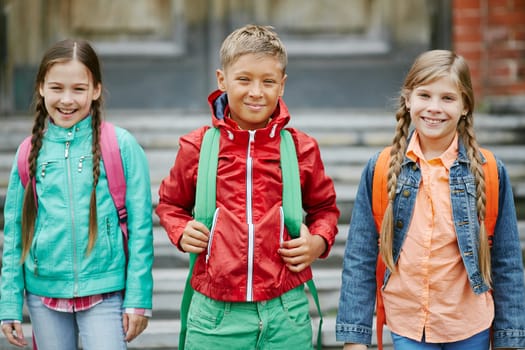 Group of cute schoolmates with backpacks looking at camera