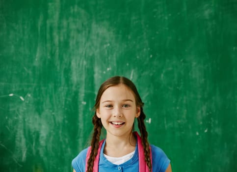 Cute youngster with backpack looking at camera with smile