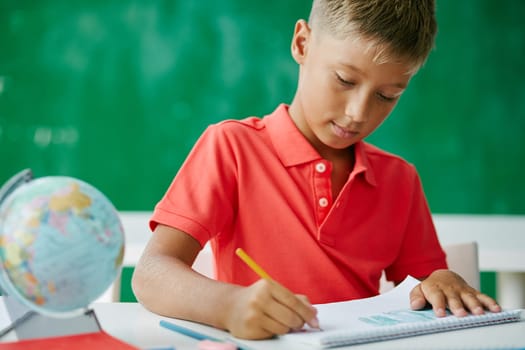 Clever schoolboy drawing at lesson in school