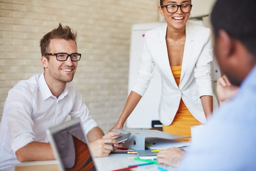 Smiling business partners talking to colleagues at meeting