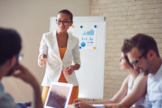 Group of employees listening to confident teacher explaining subject at seminar