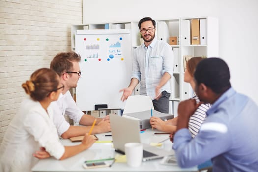 Modern employees listening to handsome teacher explaining subject at seminar