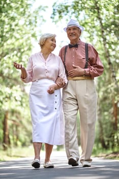 Affectionate seniors chilling out in park in summer