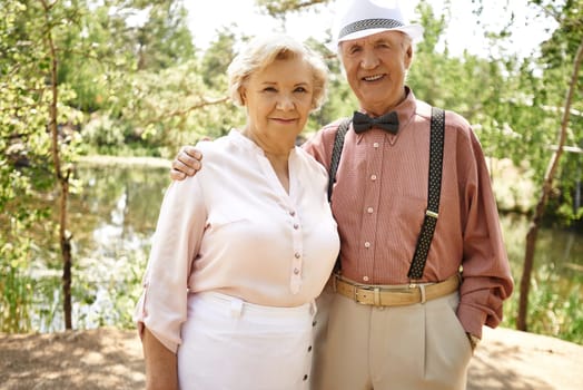 Amorous seniors looking at camera in park