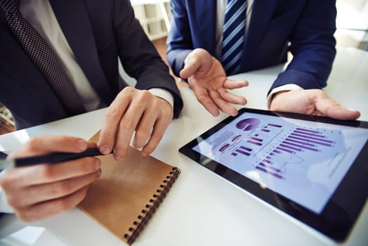 Businessmen discussing electronic data in touchpad