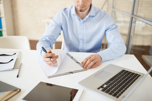 Close-up of employee looking through papers at workplace
