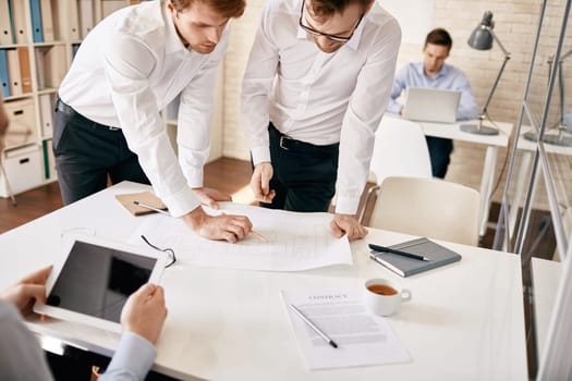 Two male architects discussing blueprint