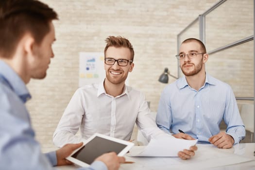 Three businessmen discussing plans and strategies at meeting