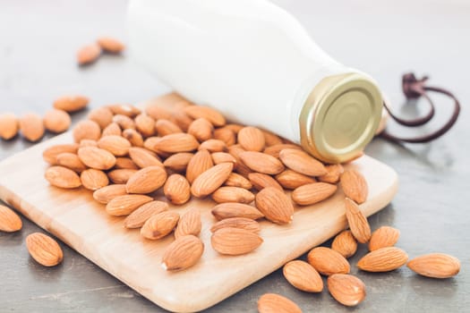 Almond nuts on wooden plate with milk, stock photo