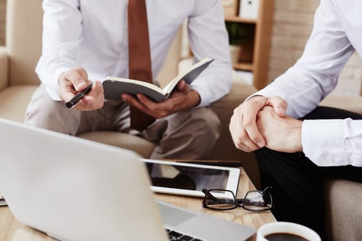 Male employee pointing at laptop while explaining data at meeting