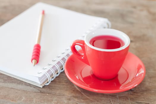 Red mug with open notebook, stock photo
