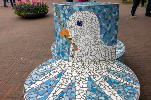 The Hague, Netherlands - April 17, 2023: A bench with a white dove holding an olive branch a symbol of peace in front Peace Palace in The Hague, which houses the International Court of Justice