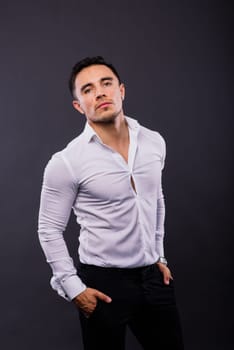 Cheerful young guy 20s in classic shirt isolated on a dark wall background studio portrait.