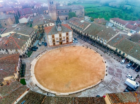 City Hall In Town Square Of Riaza Cradle Of The Red Villages In addition Of Beautiful Medieval Town In Segovia,  with a church in the background on a day with thick fog and mystical atmosphere. Spain