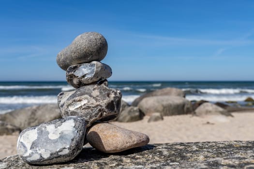 Stone pyramids on the dreamy Baltic Sea sandy beach on Rügen to the spectacular orange sunset
