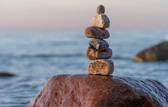 Stone pyramids on the dreamy Baltic Sea sandy beach on Rügen to the spectacular orange sunset