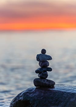 Stone pyramids on the dreamy Baltic Sea sandy beach on Rügen to the spectacular orange sunset