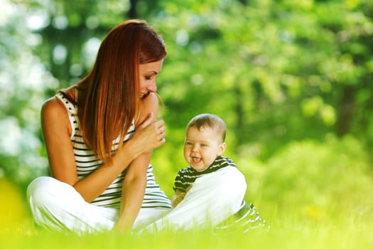 Happy mother and daughter on the green grass