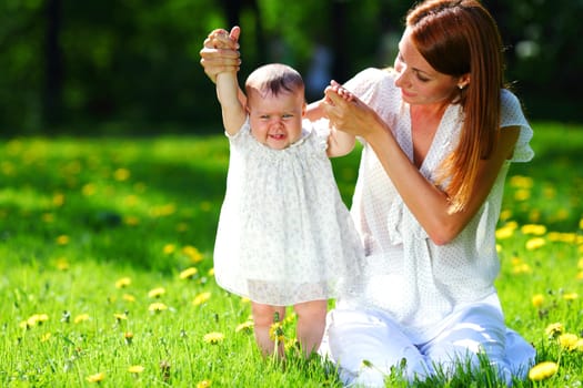 Happy mother and daughter on the green grass