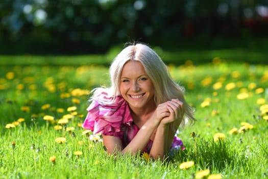 girl lying on the field of dandelions