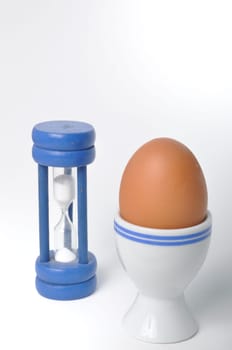 Boiled egg and hourglass on a white background