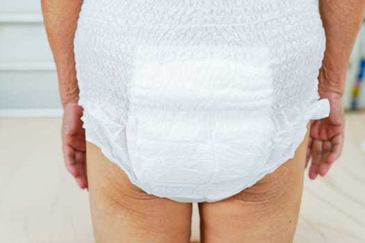 Asian elder senior woman patient wearing adult incontinence diaper pad in hospital.