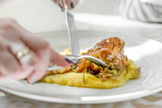 Cooked roast with italian polenta with microgreens served in a white porcelain plate. Italian food.