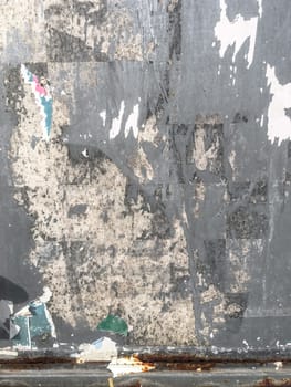 Grunge ripped poster background. Texture of torn advertisement on an old rusty billboard panel.