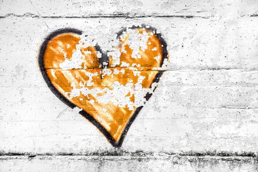 Painted orange abstract heart shape love symbol, dirty wall background, metaphor to urban and romantic valentine, grunge style.