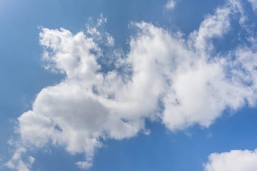 Blue sky background with white fluffy clouds.