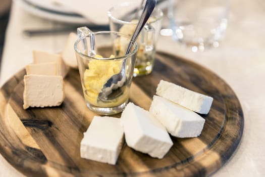 Wooden plate with cheese and sauces. Antipasti. Party. Events.