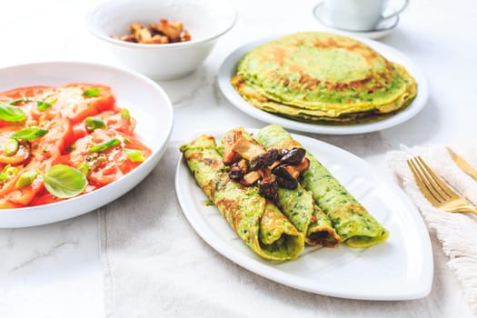 Savory wirld garlic (ramson, bear leek, Allium ursinum) pancakes with tomato salad