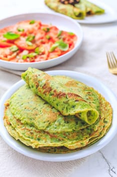 Savory wirld garlic (ramson, bear leek, Allium ursinum) pancakes with tomato salad