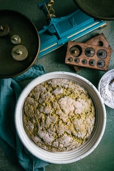 Homemade spelt bread with herbs and wild garlic, process of raising dough in a special basket. Dough made from natural sourdough, fermentation process