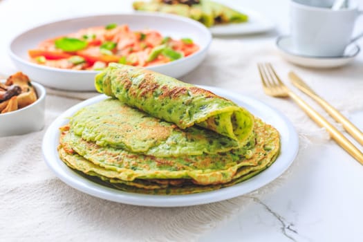 Savory wirld garlic (ramson, bear leek, Allium ursinum) pancakes with tomato salad