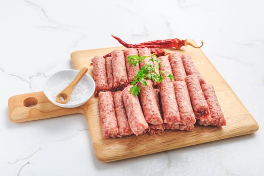 Raw serbian cevapi or cevapcici sausages. Traditional south european skinless sausages cevapcici made of ground meat and spices.