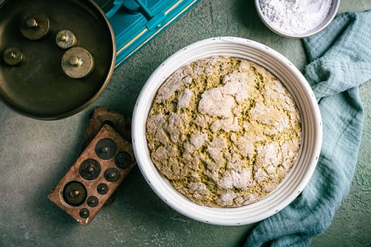 Homemade spelt bread with herbs and wild garlic, process of raising dough in a special basket. Dough made from natural sourdough, fermentation process