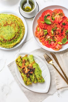 Savory wirld garlic (ramson, bear leek, Allium ursinum) pancakes with tomato salad