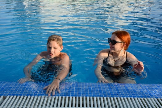A boy and a teenage girl in a swimming pool