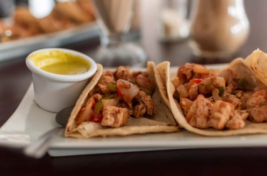 Delicious Mexican chicken tacos with salsa and pico de gallo served on the table, View of chicken tacos served on the table. Close-up of Mexican chicken tacos served