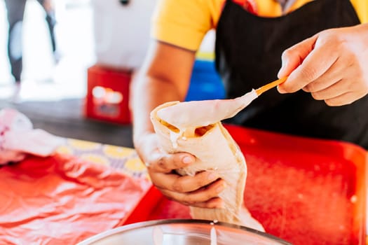Close up of hands making a traditional quesillo with pickled onion. Hands making a delicious quesillo. Preparation of Nicaraguan quesillo, traditional Central American food quesillo