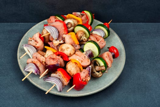 Fresh skewers with pieces of raw meat and vegetables marinated in herbs. Raw shashlik and vegetables