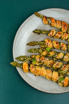 Dietary bread sticks stuffed with asparagus and pesto sauce on a plate.