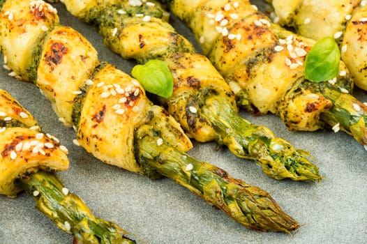 Dietary bread sticks stuffed with asparagus and pesto sauce on a plate.